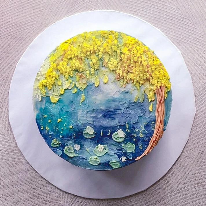 A hand-painted Canvas cake, blue water and yellow wisteria in buttercream