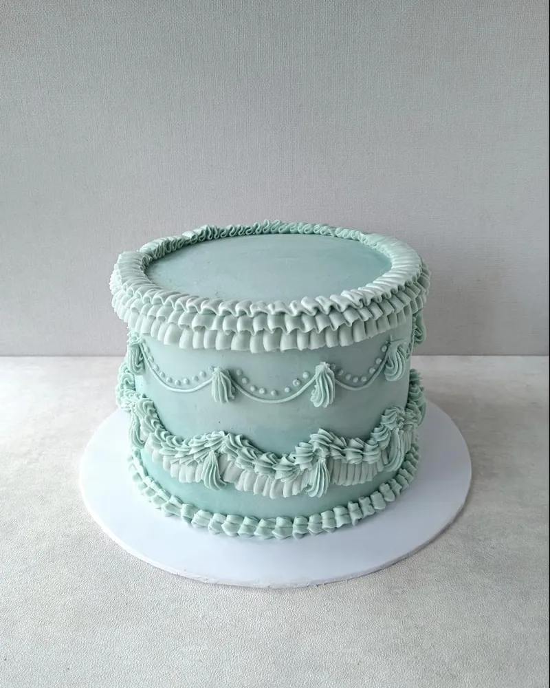 A vintage lace-piped cake in soft teal