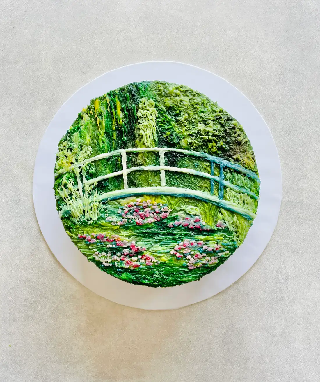 A Fig & Owl Canvas cake hand-painted with Monet's water-garden bridge in green buttercream