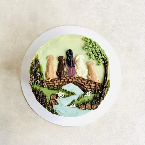 A painted bridge and waterfall scene on a cake